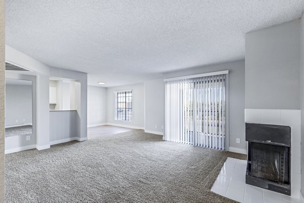 Bright living room with modern decor at Fountain Palms Apartments, featuring a cozy seating area and large windows