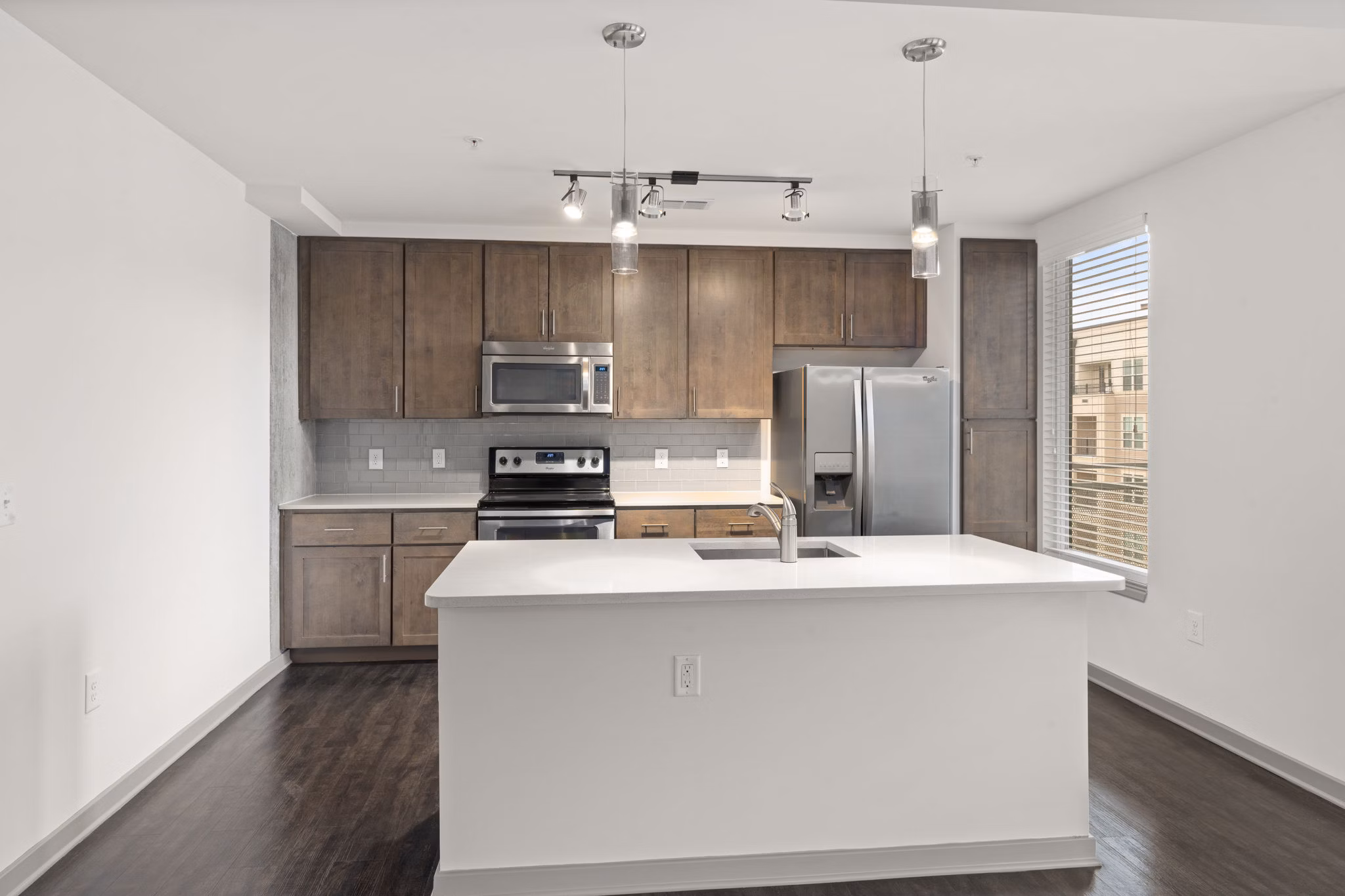 Modern kitchen with stainless steel appliances and granite countertops at The Devon Four25 Apartments