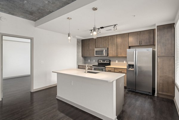 Modern kitchen with stainless steel appliances at The Devon Four25 Apartments