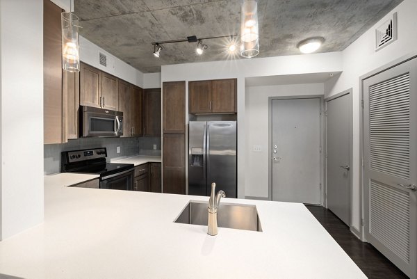 Modern kitchen featuring stainless steel appliances at The Devon Four25 Apartments