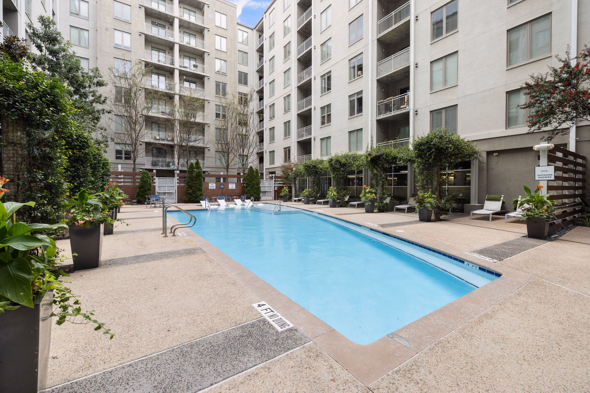 Luxurious outdoor pool area at The Devon Four25 Apartments featuring modern loungers and water features for ultimate relaxation