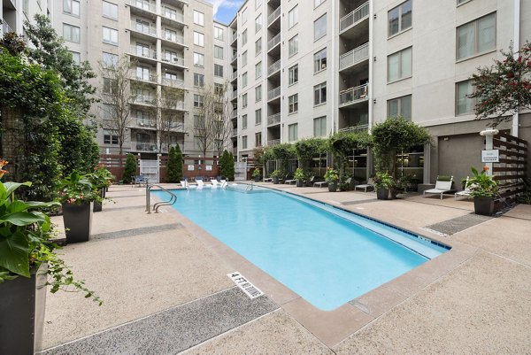 Luxurious outdoor pool area at The Devon Four25 Apartments featuring modern loungers and water features for ultimate relaxation