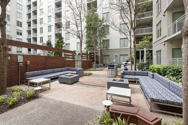 Outdoor grill area with modern seating at The Devon Four25 Apartments