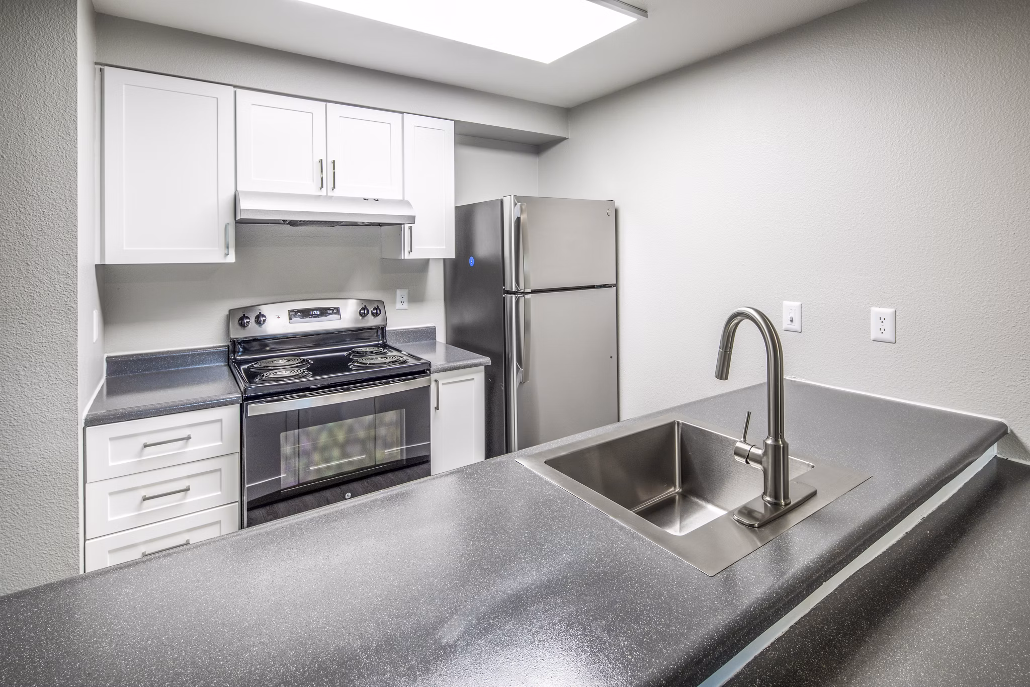 Modern kitchen featuring stainless steel appliances and quartz countertops at Avana at Happy Valley Apartments