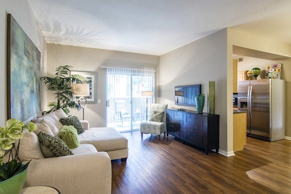 Modern living room featuring plush seating and large windows at Estancia at City Center Apartments, embodying luxury and comfort