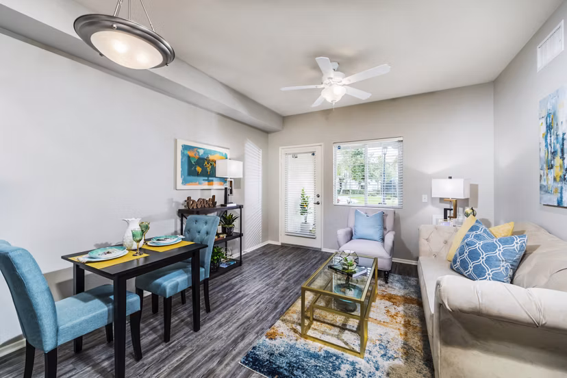 Spacious living room with modern furnishings and large windows in Overture Riverwalk luxury apartments