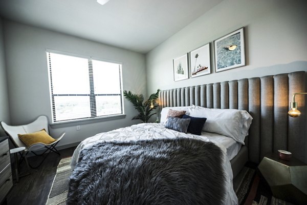 Modern bedroom with chic decor and ample natural light at Corazon Apartments in Austin, offering luxury living spaces