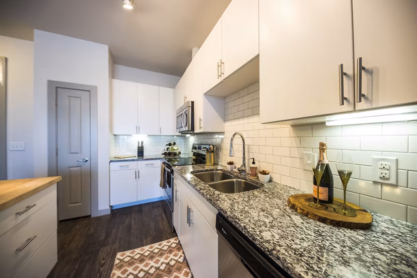 Sleek kitchen featuring stainless steel appliances and granite countertops in Corazon Apartments