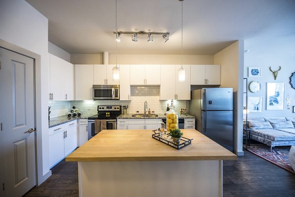 Sleek kitchen featuring stainless steel appliances and granite countertops in Corazon Apartments