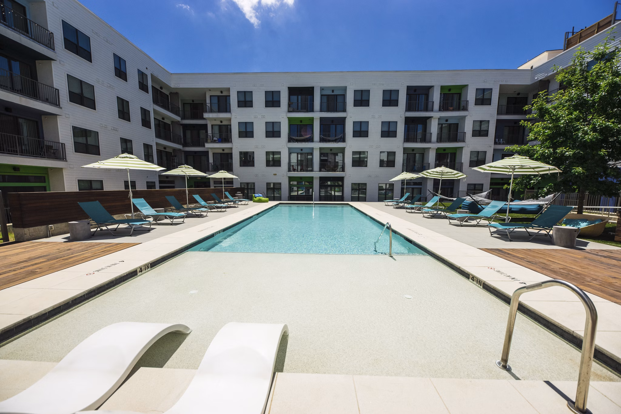 Outdoor pool with sleek lounge chairs at Corazon Apartments, a luxury property by Greystar Enjoy leisure and relaxation in this modern setting