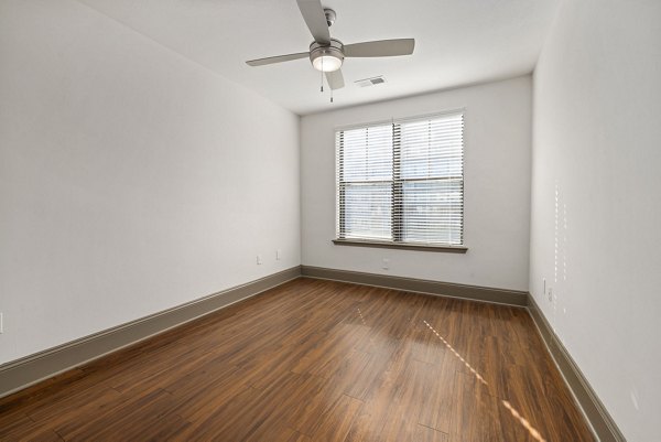 Bedroom with modern decor and large windows at Midtown Green Apartments