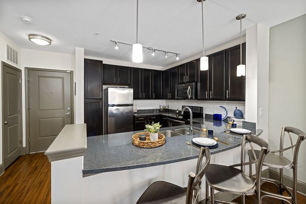 Modern kitchen featuring stainless steel appliances and granite countertops in Midtown Green Apartments