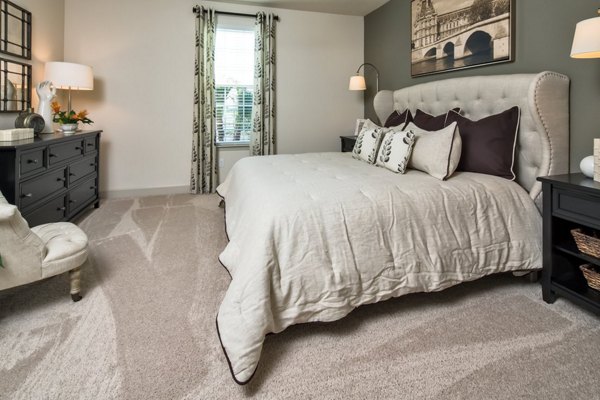 Modern bedroom with natural light and cozy furnishings at The Retreat at Trinity Apartments