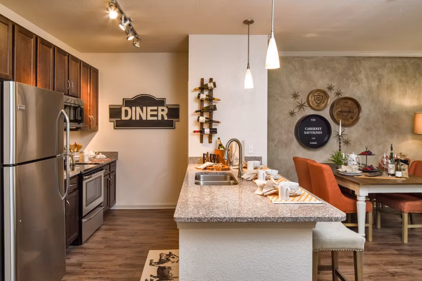 Modern kitchen with quartz countertops and stainless steel appliances at The Retreat at Trinity Apartments