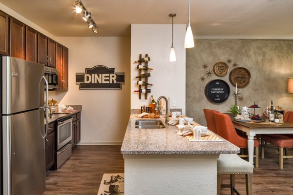 Modern kitchen with quartz countertops and stainless steel appliances at The Retreat at Trinity Apartments