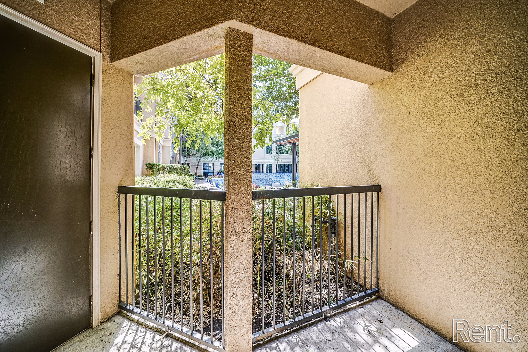 Patio with comfortable seating and greenery at The Millennium Waterway apartments