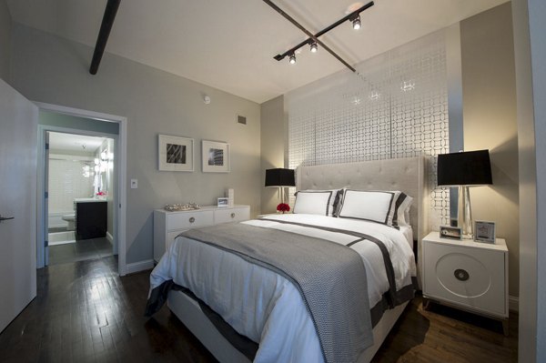 Chic bedroom featuring elegant decor and abundant natural light at The Rice Apartments