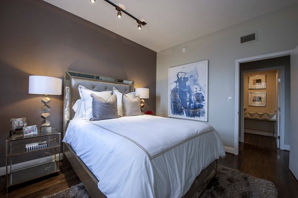 Cozy bedroom with plush bedding and modern decor in The Rice Apartments