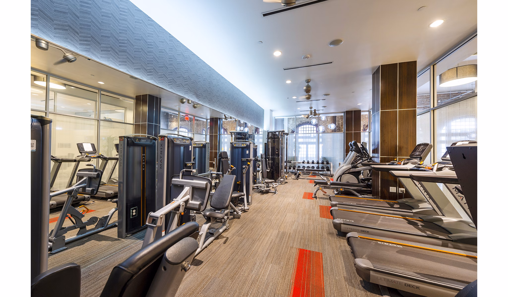 The Rice Apartments: Modern fitness center with state-of-the-art equipment and bright lighting for resident wellness