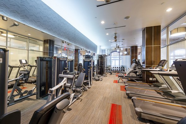 The Rice Apartments: Modern fitness center with state-of-the-art equipment and bright lighting for resident wellness