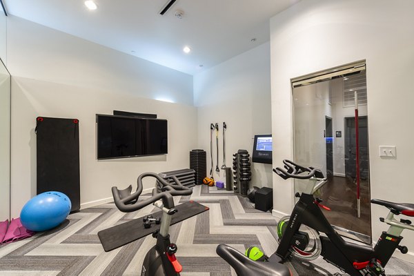 Fitness center equipped with modern exercise machines at The Rice Apartments
