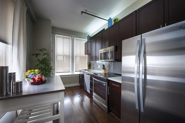 Modern kitchen with stainless steel appliances in The Rice Apartments, offering a luxury living experience in a premiere location