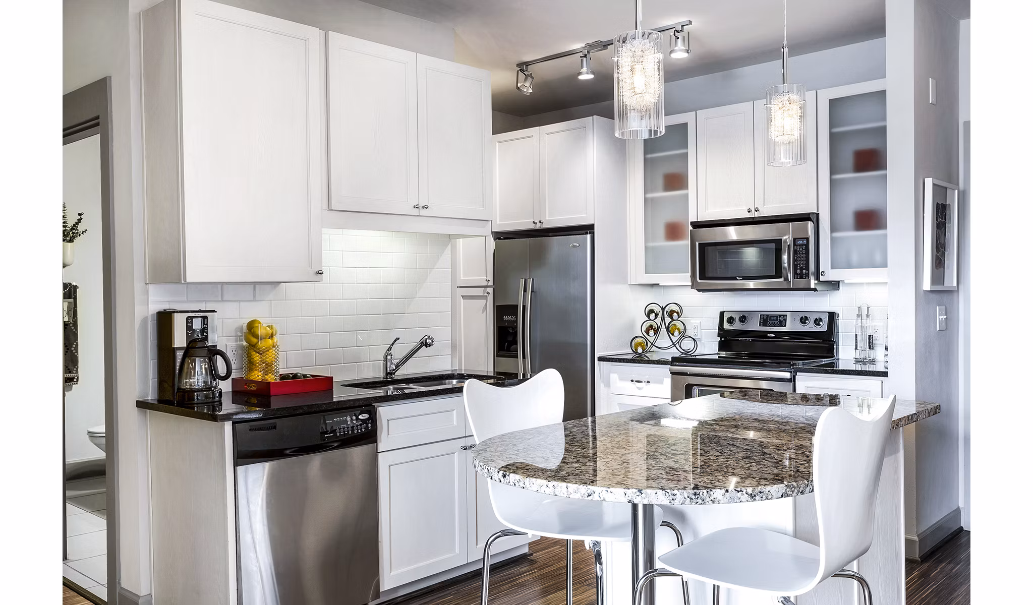 Modern kitchen with stainless steel appliances in 5th Street Commons Apartments