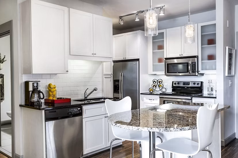 Modern kitchen with stainless steel appliances in 5th Street Commons Apartments