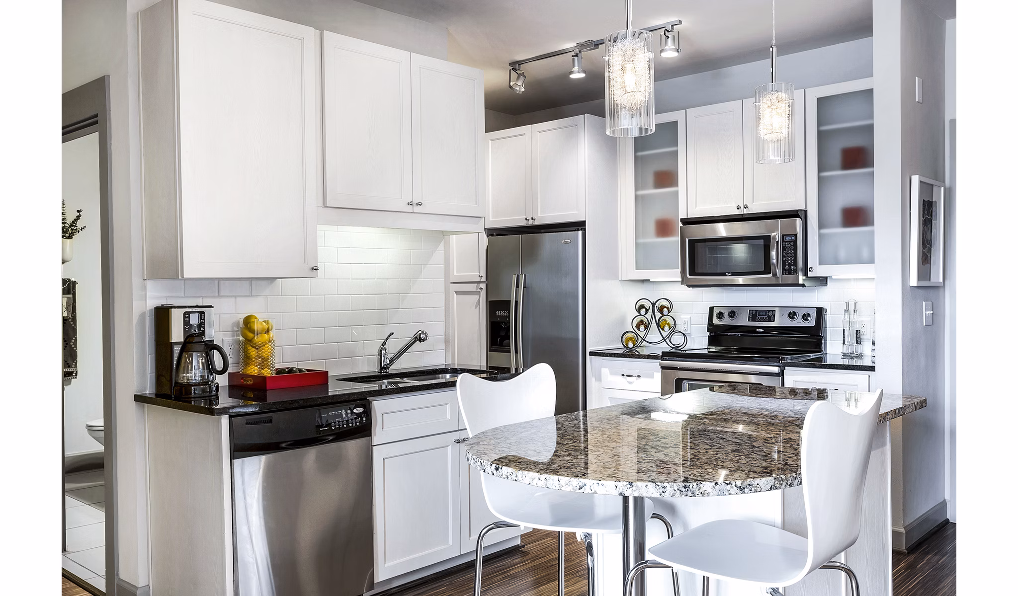 Modern kitchen with stainless steel appliances in 5th Street Commons Apartments