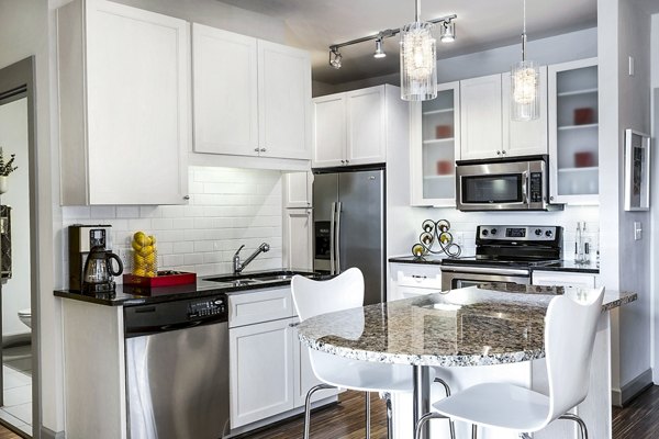 Modern kitchen with stainless steel appliances in 5th Street Commons Apartments