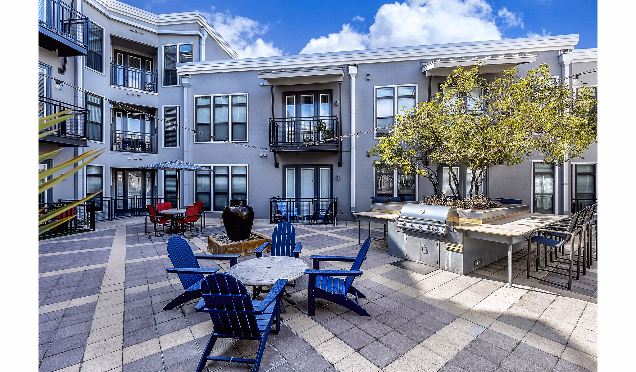 Outdoor grill area with seating at 5th Street Commons Apartments, perfect for social gatherings and dining al fresco