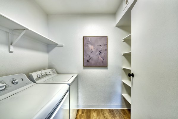Laundry room with top-load washers and dryers in Be Mesa Apartments