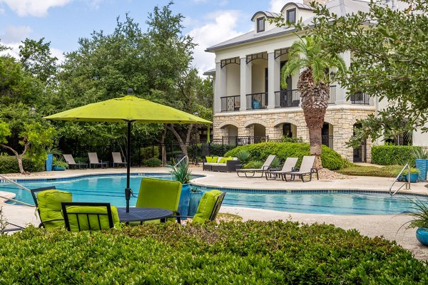 Resort-style pool with lounge chairs at Lantana Hills Apartments, offering luxury living in a serene environment