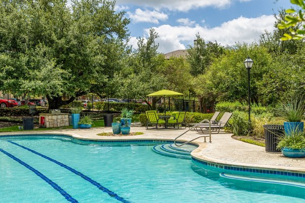 Relaxing poolside area at Lantana Hills Apartments with lush landscaping and modern design