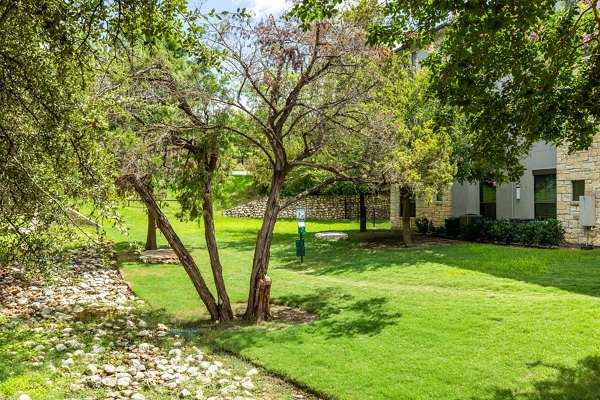 Outdoor recreational area with green landscaping at Lantana Hills Apartments