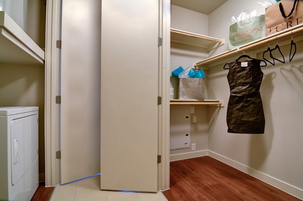 Walk-in closet featuring built-in shelves and ample storage space in River House Apartments