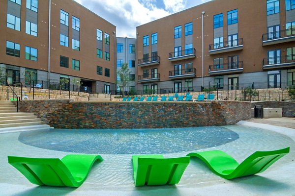 Riverside pool with lounge chairs at River House Apartments offering luxury leisure amenities