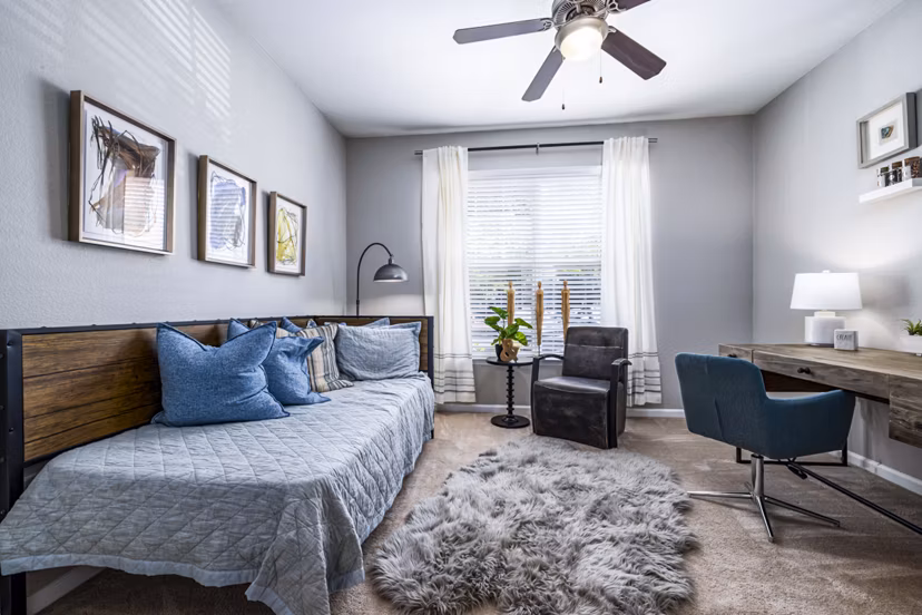 Cozy bedroom with a dedicated home office space at Columns at Wakefield luxury apartments, ideal for remote work and relaxation