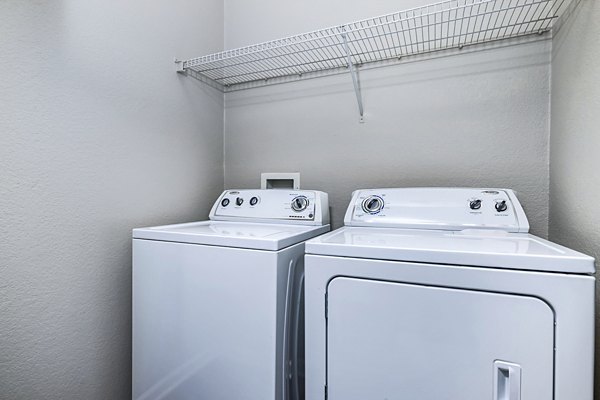 Modern laundry room with high-efficiency washers and dryers at Columns at Wakefield apartments