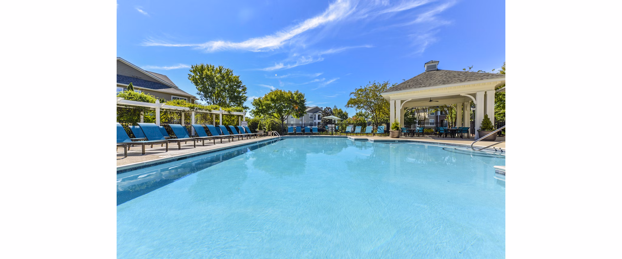 Resort-style pool with sun loungers at Columns at Wakefield Apartments, offering a luxurious outdoor experience