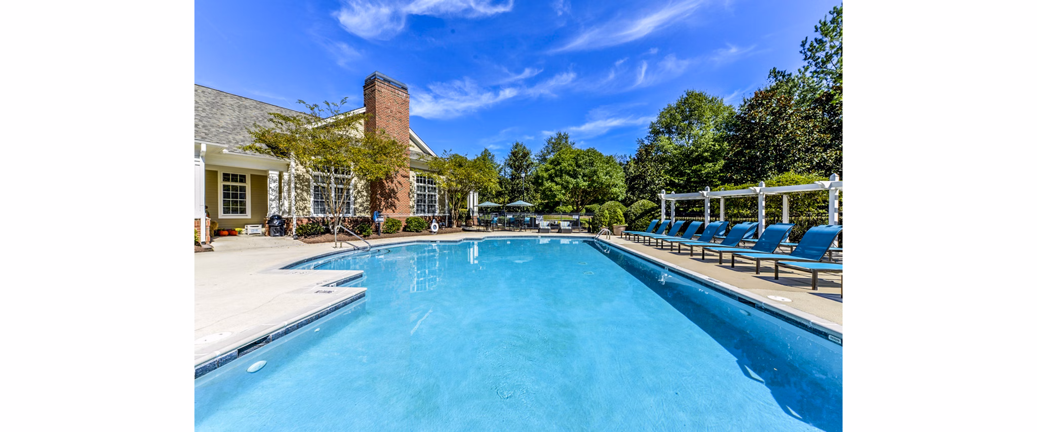 Outdoor pool with lounge chairs at Columns at Wakefield Apartments