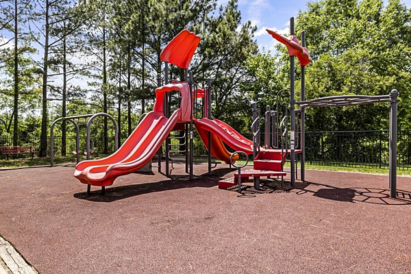 Children's playground at Columns at Wakefield featuring slides and swings, luxury family amenities in this Greystar community