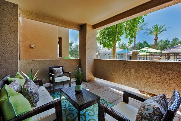 Pinnacle Terrace Apartments: Cozy patio balcony with outdoor seating and green views, perfect for relaxation in a lush community setting