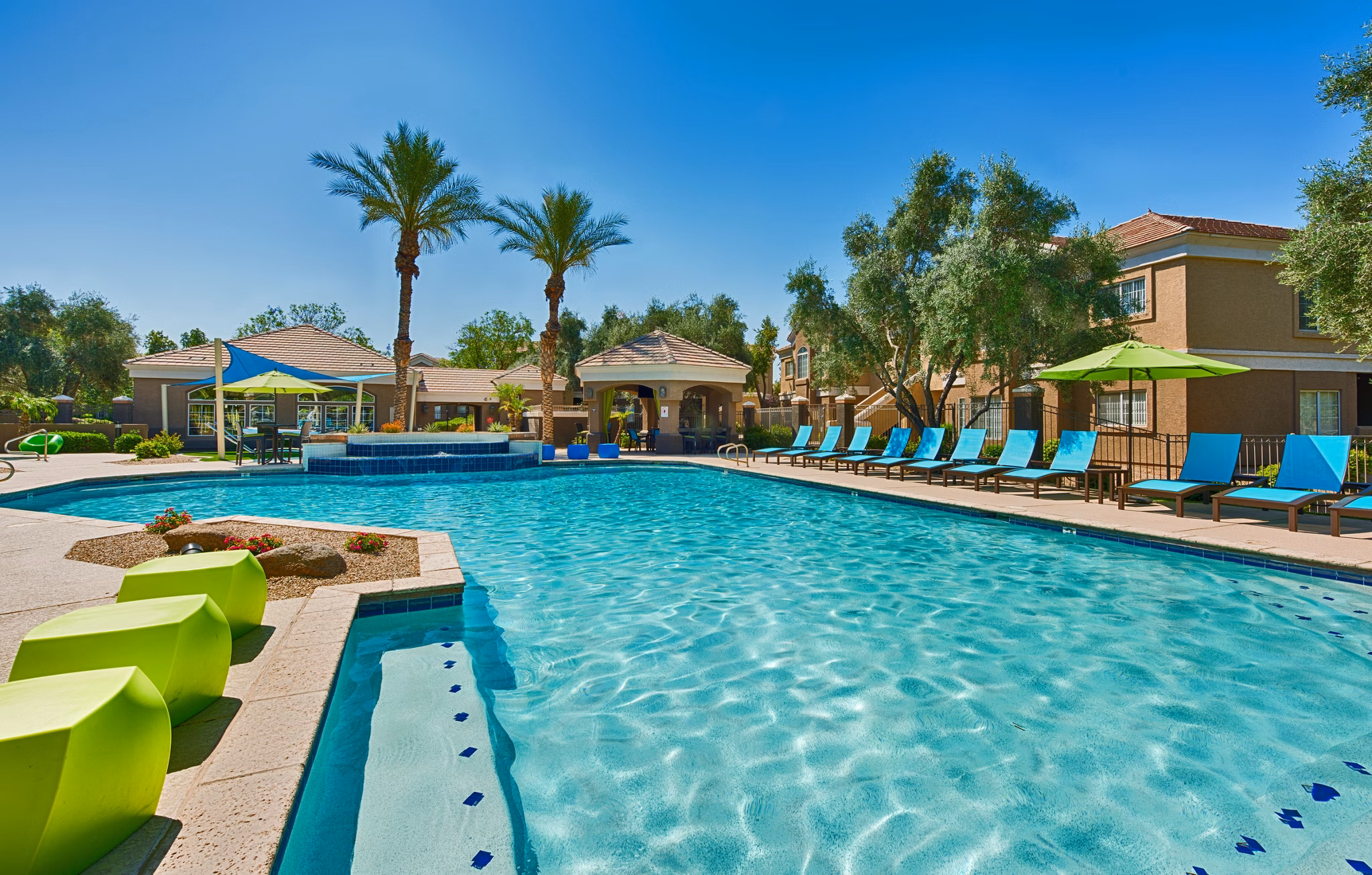 Resort-style pool with surrounding lounge chairs at Pinnacle Terrace Apartments