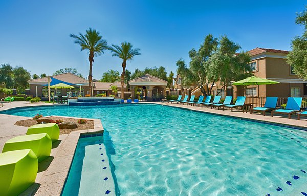Resort-style pool with surrounding lounge chairs at Pinnacle Terrace Apartments