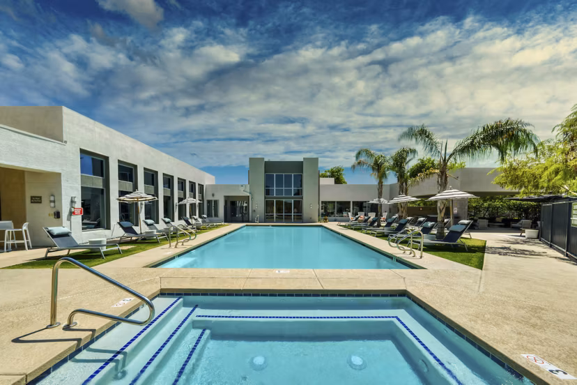 Resort-style pool with lounge chairs at Seven Apartments