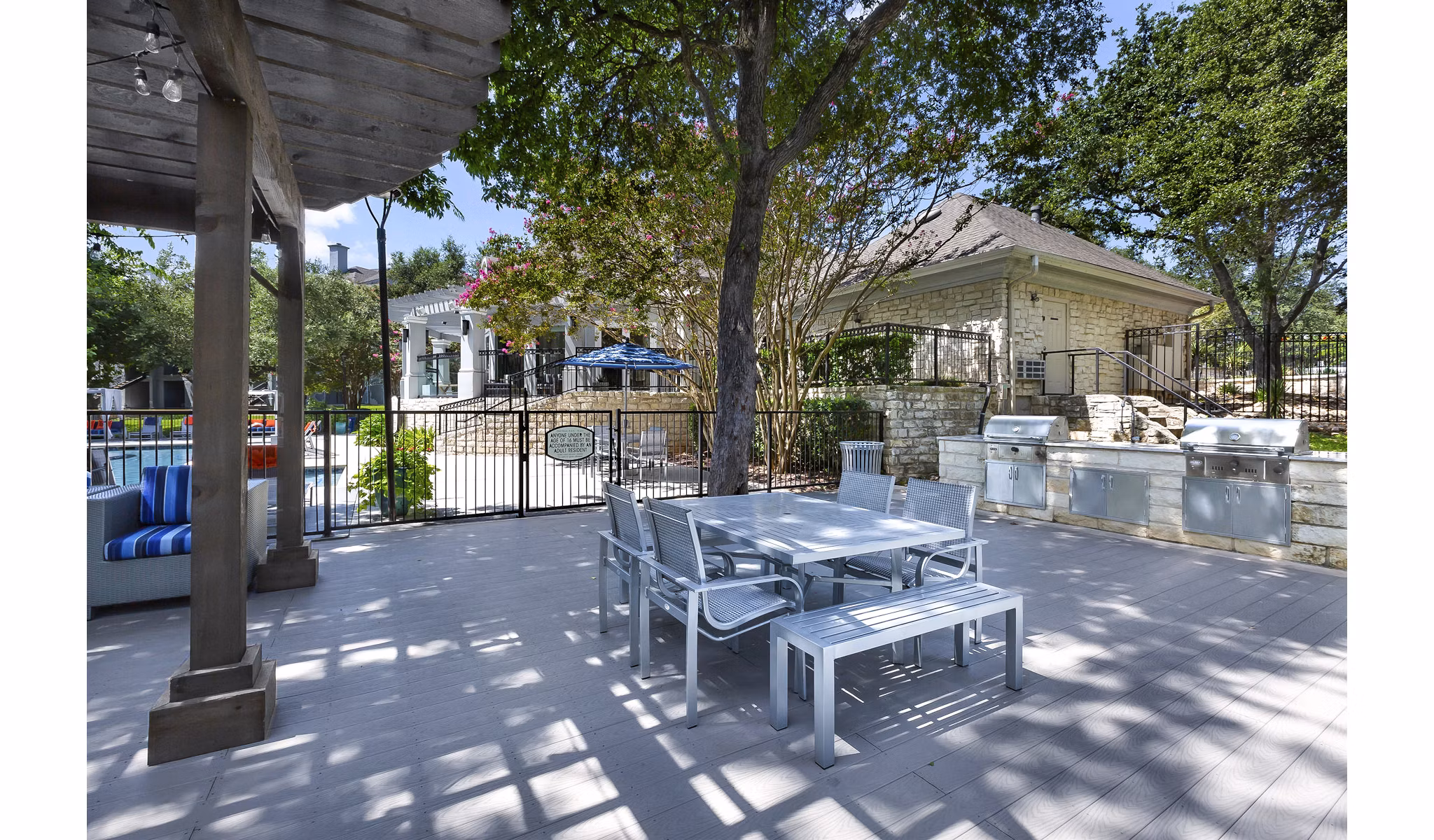 Outdoor grill area surrounded by lush gardens at Folio Luxury Apartments, ideal for communal gatherings and barbecues