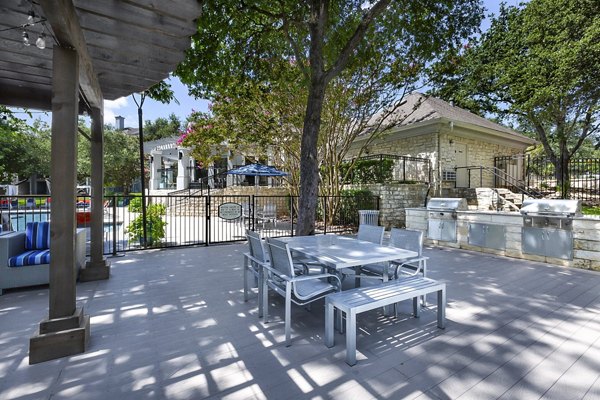 Outdoor grill area surrounded by lush gardens at Folio Luxury Apartments, ideal for communal gatherings and barbecues