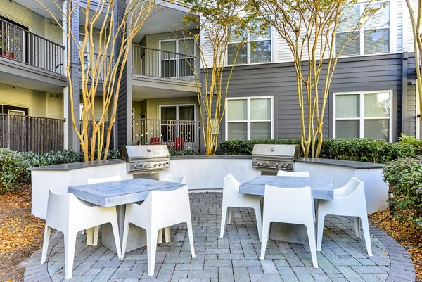 Outdoor grill area with seating at Avana Westside Apartments, perfect for social gatherings and cookouts