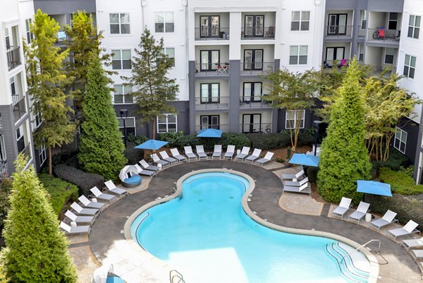 Resort-style swimming pool with lounge seating at Avana Westside Apartments